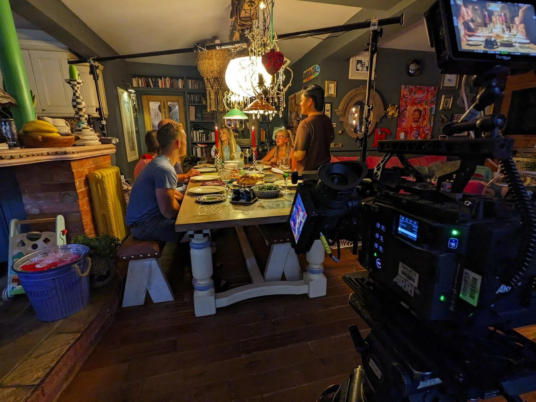 A studio light with a china ball suspended over a long dining table.